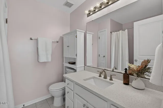a bathroom with a granite countertop sink a toilet and a large mirror