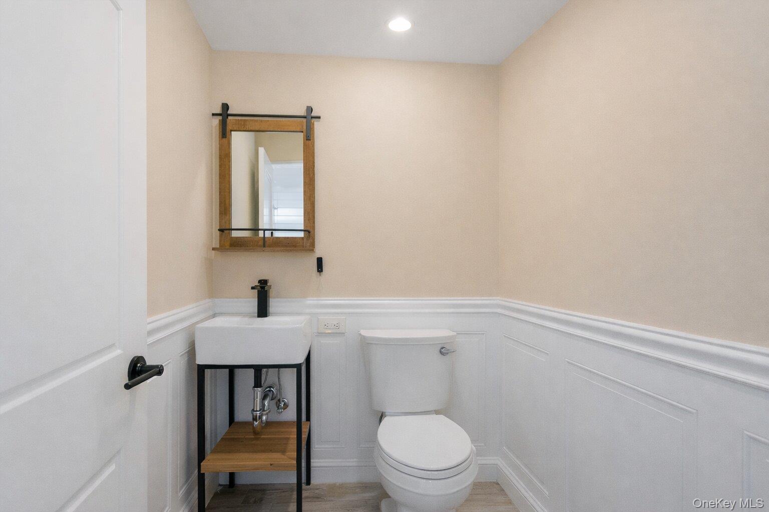 2 Richmond Road, Unit 2A Lido Beach, NY 11561 - Photo 9 of 12 a bathroom with a toilet a sink and mirror