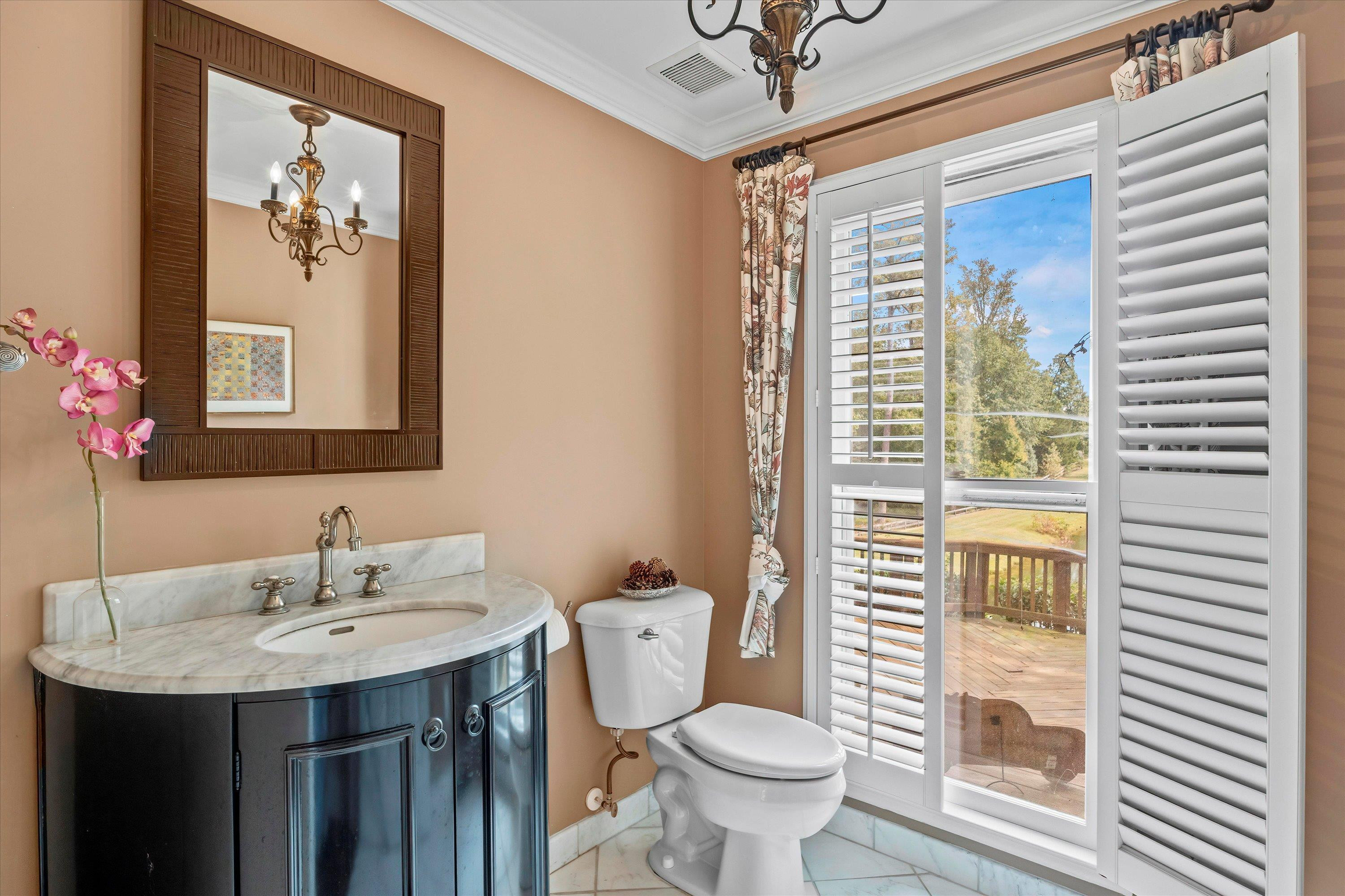 3509 Old Milburnie Road Raleigh, NC 27616 - Photo 24 of 74 a bathroom with a toilet a sink a mirror and a window