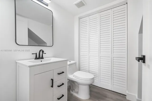 a bathroom with a toilet a sink and a mirror