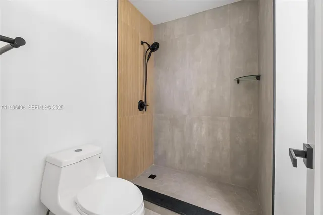 a bathroom with a toilet and a shower