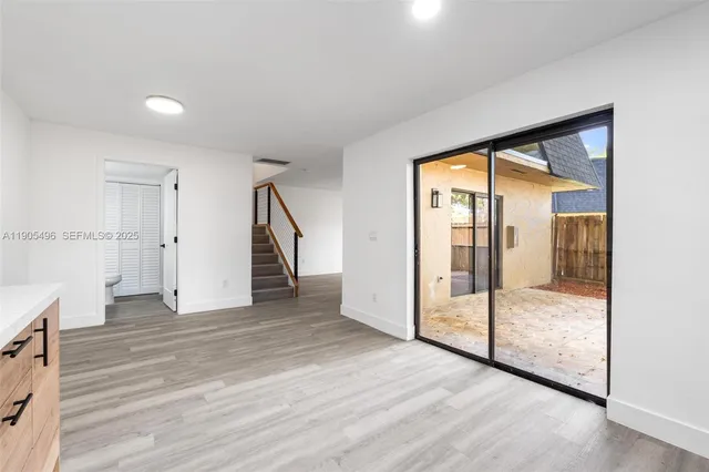 a view of a hallway with wooden floor and cabinet