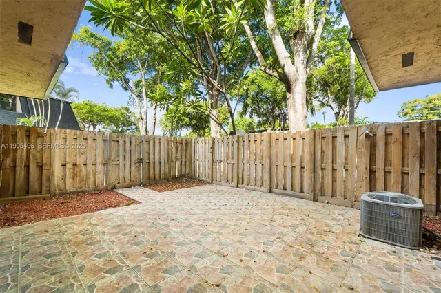 a backyard of a house with lawn chairs and wooden fence
