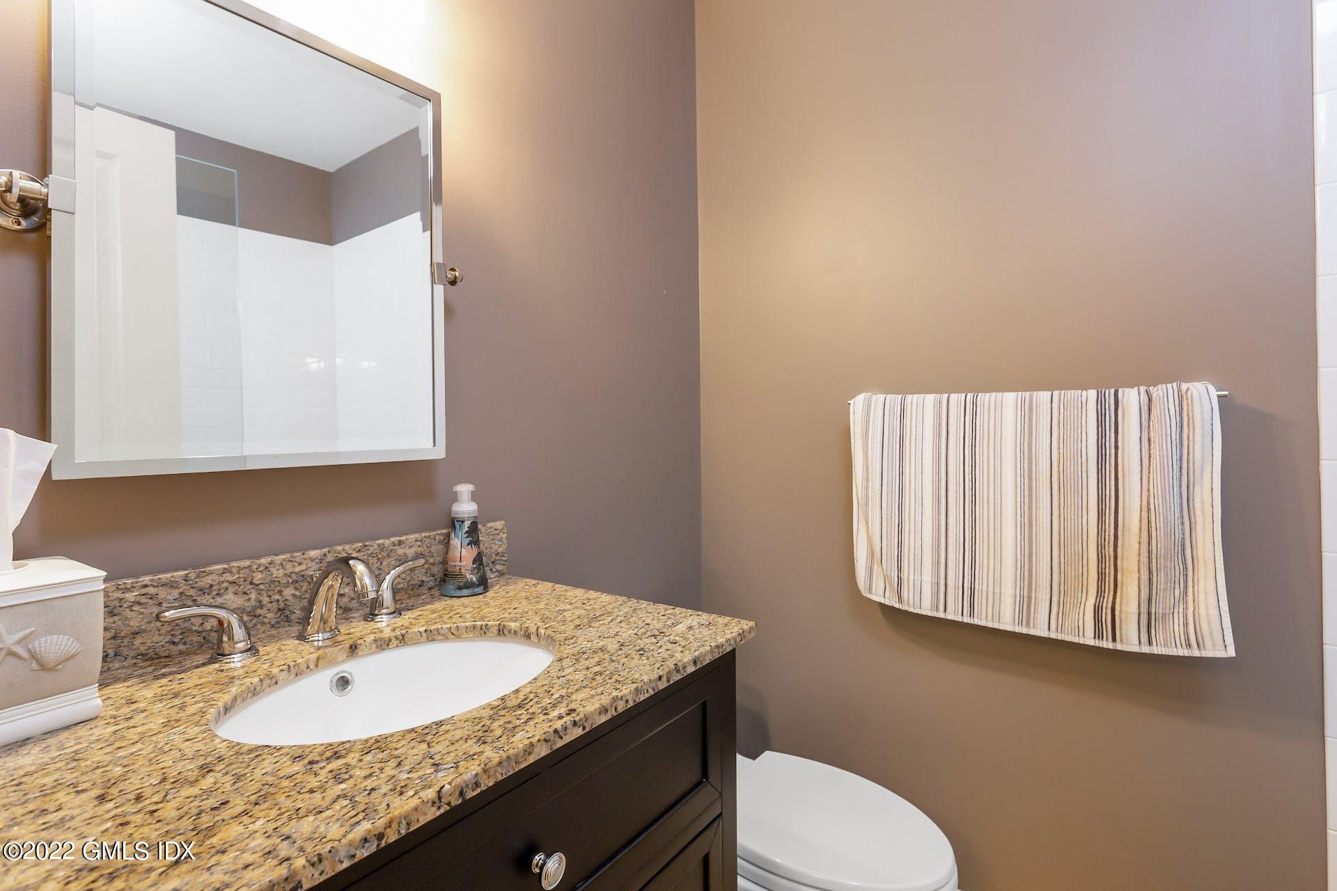 100 Silo Circle, Unit 100 Riverside, CT 06878 - Photo 8 of 22 a bathroom with a granite countertop sink and a mirror