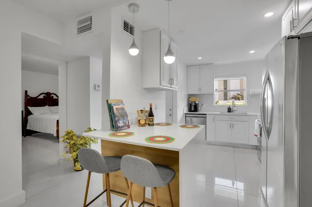 a kitchen with a dining table chairs and refrigerator