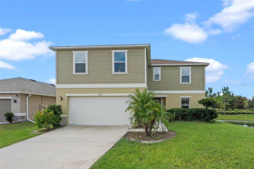 a front view of a house with a garden and plants