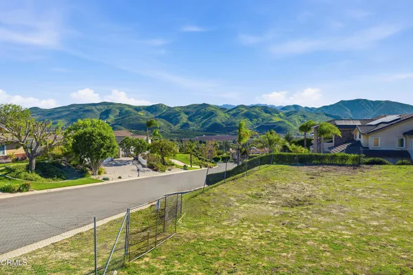 a view of house with garden space and mountain view in back
