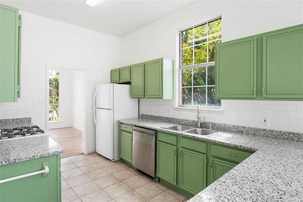 559 Raintree Circle Coppell, TX 75019 - Photo 13 of 40 Kitchen featuring green cabinetry, granite-finish countertops, subway tile backsplash, and a double basin stainless steel sink