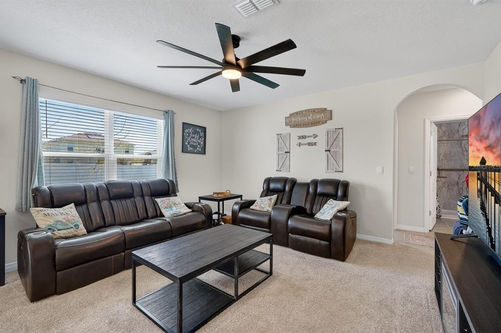 1809 Myrtlebrooke Drive Edgewater, FL 32141 - Photo 7 of 58 a living room with furniture a ceiling fan and a window