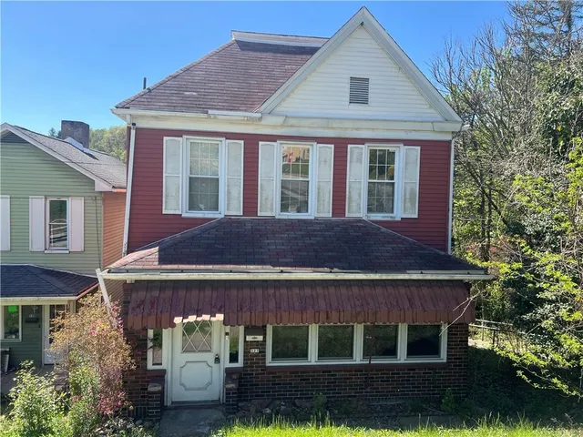 a view of a house with a yard and potted plants