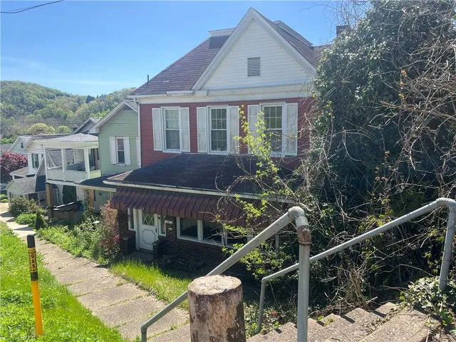 a house with tall trees in front of it