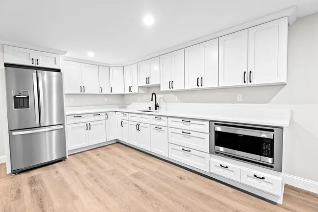 a kitchen with granite countertop white cabinets and stainless steel appliances