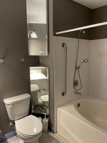a white toilet and tub sitting next to a bathroom sink