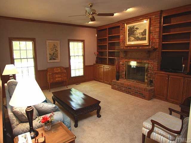 1432 Kildaire Farm Road Cary, NC 27511 - Photo 3 of 17 Quality shines forth in this newly carpeted great room with masonry fireplace and beautiful wood wainscoting and built in book shelves and cabinets.