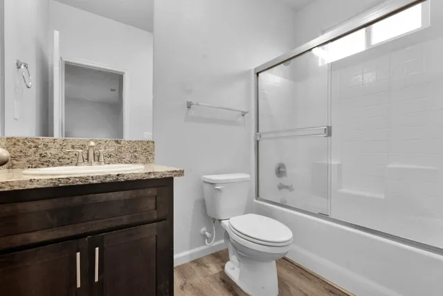 a bathroom with a granite countertop sink toilet and shower