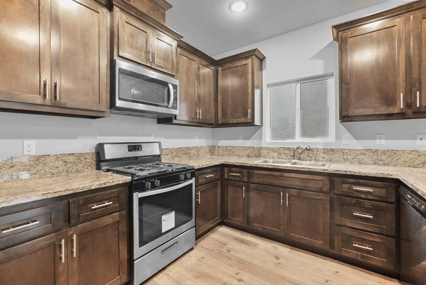 683 Granada Court Merced, CA 95341 - Photo 3 of 14 a kitchen with stainless steel appliances granite countertop a stove and a microwave