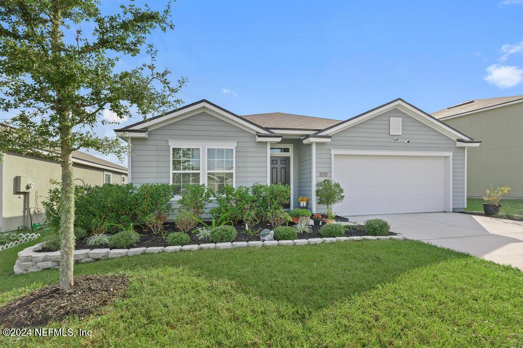 a front view of a house with a garden and plants