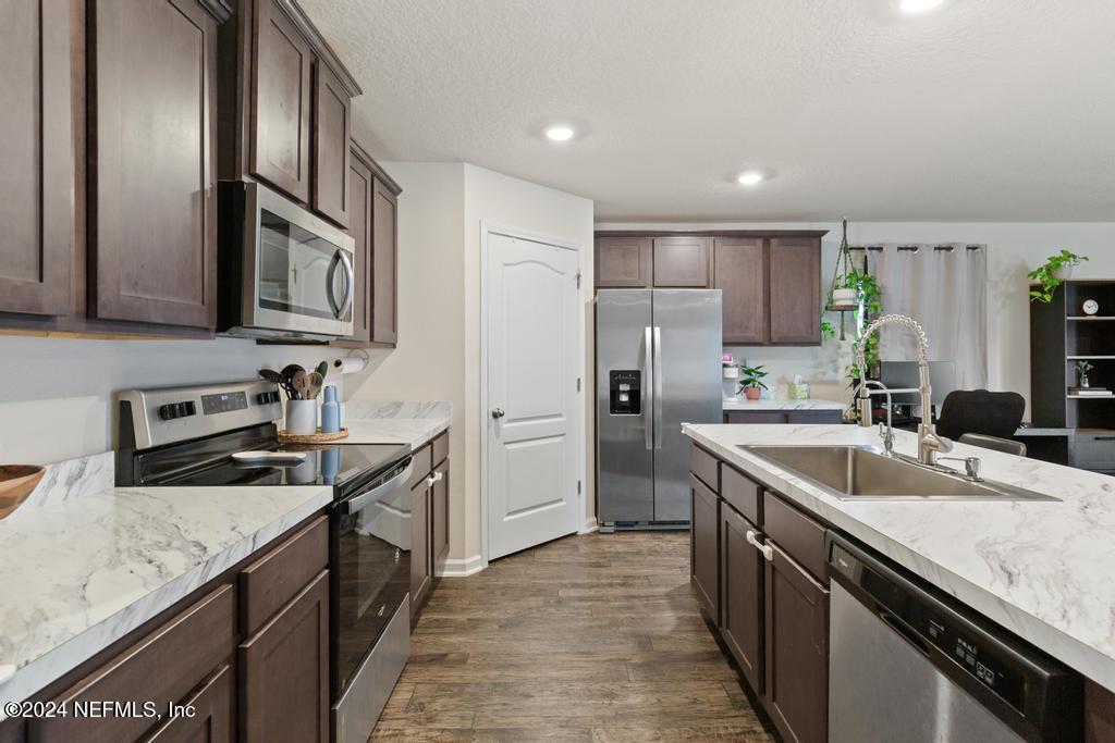 11291 Sheepshead Lane Jacksonville, FL 32226 - Photo 23 of 54 a kitchen with stainless steel appliances granite countertop a sink stove and refrigerator