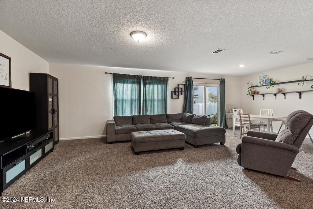 11291 Sheepshead Lane Jacksonville, FL 32226 - Photo 25 of 54 a living room with furniture and a flat screen tv