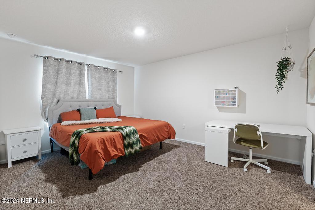 11291 Sheepshead Lane Jacksonville, FL 32226 - Photo 30 of 54 a bed room with a bed and a chair