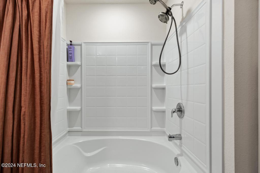 11291 Sheepshead Lane Jacksonville, FL 32226 - Photo 35 of 54 a bathroom with a bath tub and shower