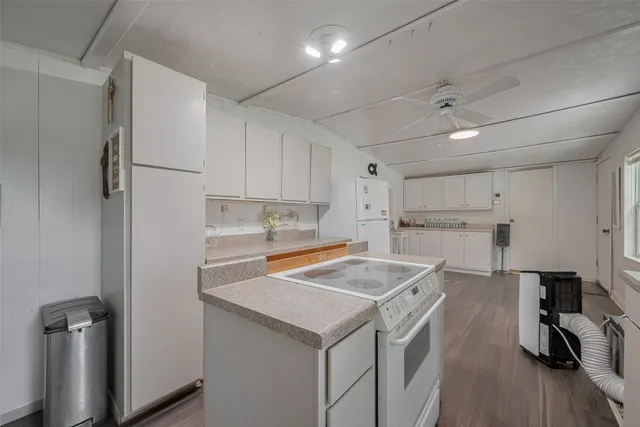 a kitchen with a sink a stove a refrigerator and white cabinets