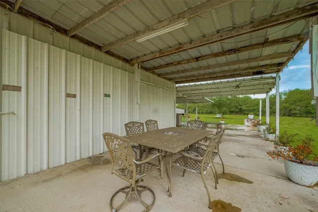 a view of a patio with table and chairs and potted plants