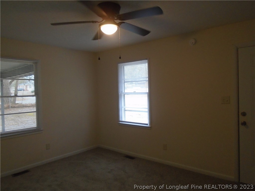 5858 Columbine Road Fayetteville, NC 28306 - Photo 2 of 10 an empty room with a window and a fan