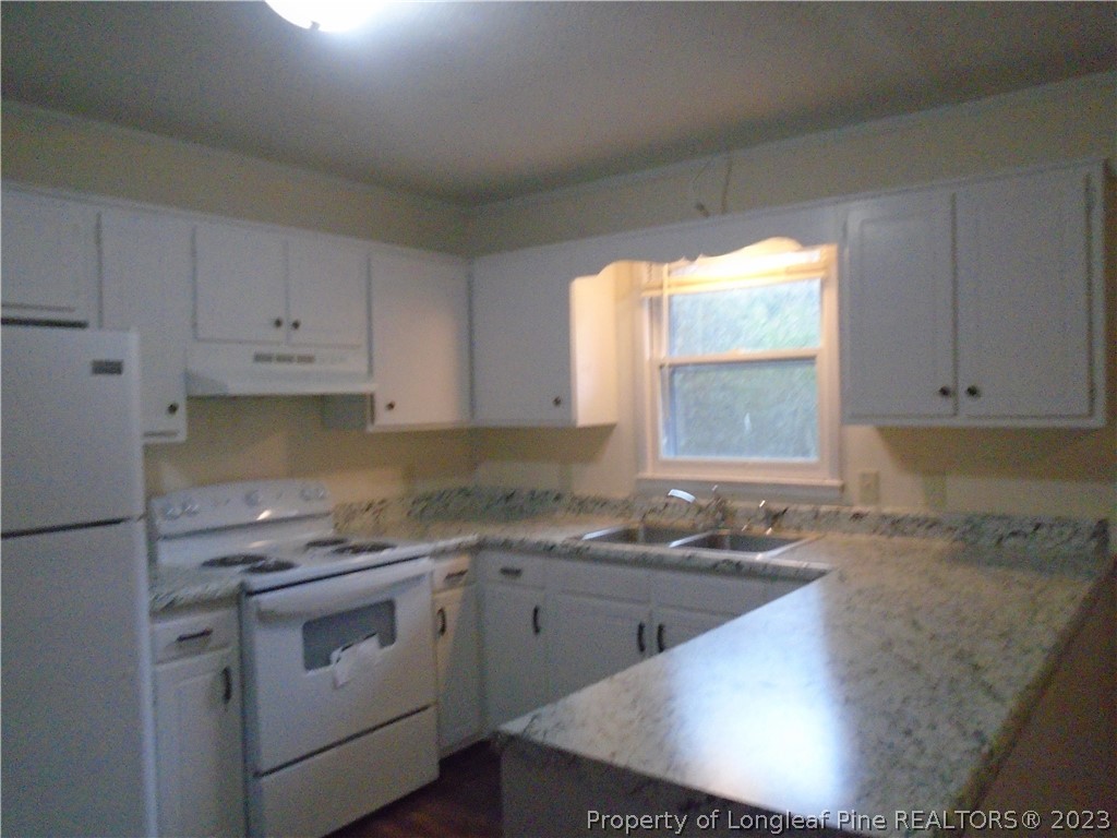 5858 Columbine Road Fayetteville, NC 28306 - Photo 3 of 10 a kitchen with granite countertop a sink stove and cabinets