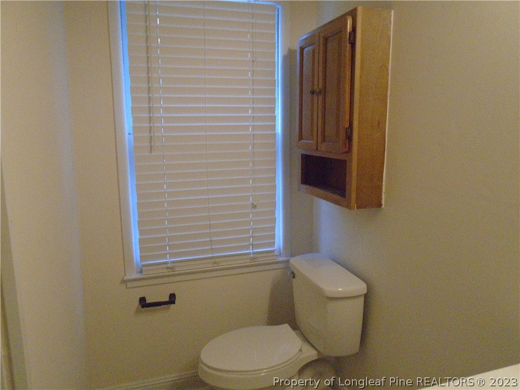 5858 Columbine Road Fayetteville, NC 28306 - Photo 8 of 10 a white toilet sitting next to a small bathroom
