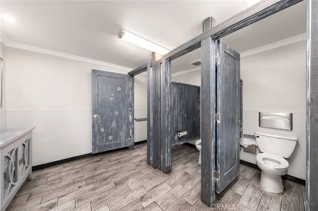 a room with stainless steel appliances kitchen island granite countertop furniture and a wooden floor