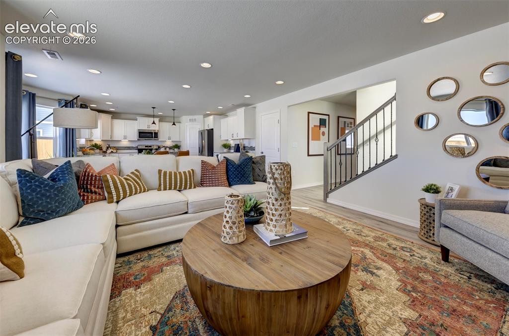 8230 Lemon Grass Road Falcon, CO 80831 - Photo 7 of 22 a living room with furniture and a dining table with wooden floor