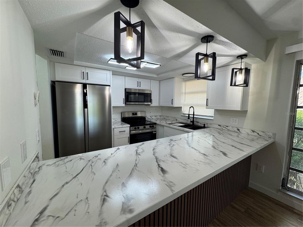 500 Vía Tripoli, Unit 3 Punta Gorda, FL 33950 - Photo 1 of 21 a kitchen with stainless steel appliances kitchen island a refrigerator and a sink