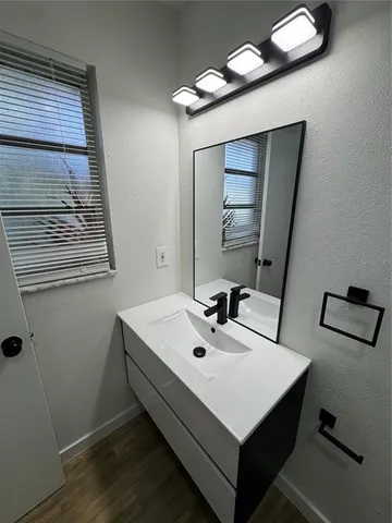 a white room with a mirror and a sink