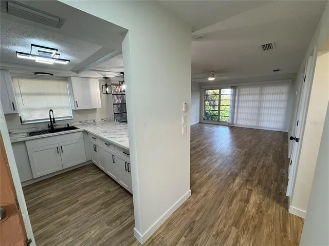 a kitchen with stainless steel appliances sink cabinets and wooden floor