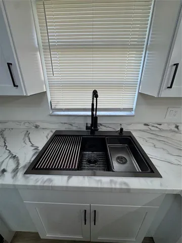 a close view of a sink a barbeque and wooden floor