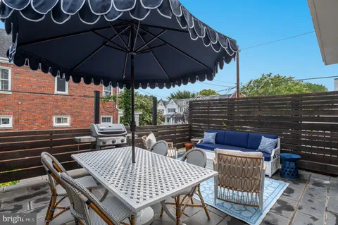 a patio with wooden floor a yard a table and chairs