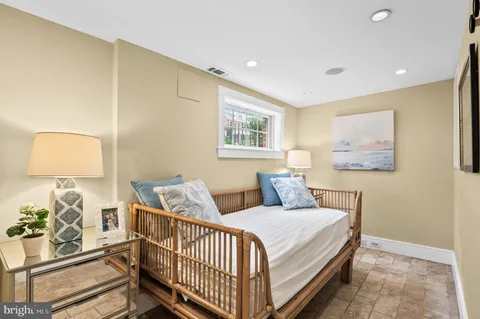 a bedroom with a bed and painting on the wall