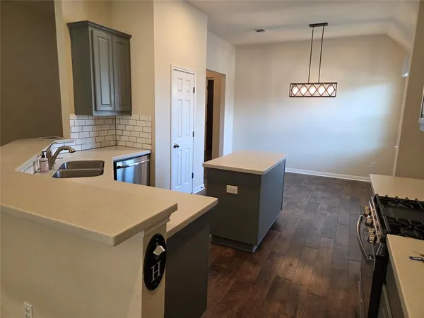 a kitchen with stainless steel appliances granite countertop a sink a stove and a refrigerator