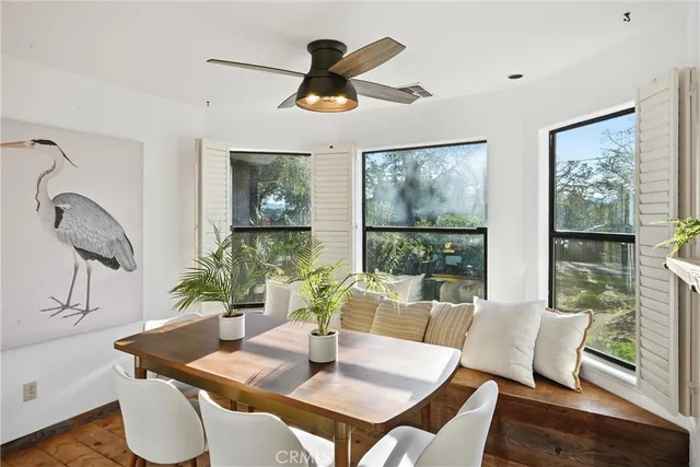a dining room with furniture a large window and wooden floor