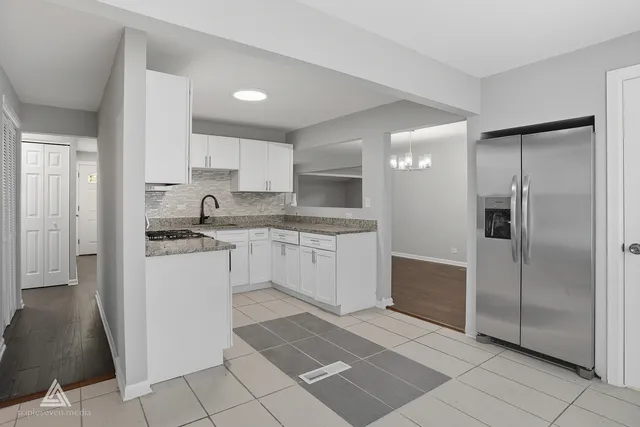 a kitchen with a refrigerator sink and cabinets