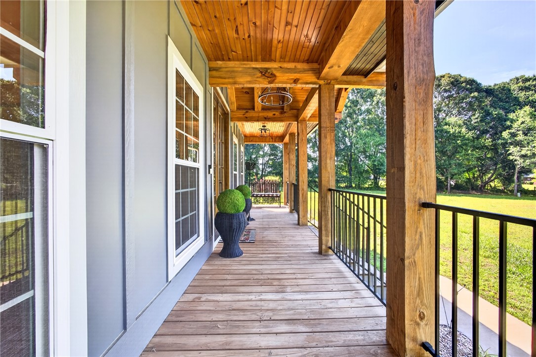 5016 Copeland Road Belton, SC 29627 - Photo 5 of 45 A spacious wooden porch extends a warm invitation to a verdant landscape.