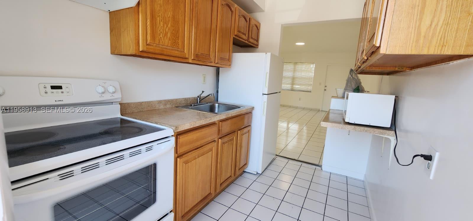 3670 Southwest 10th Street, Unit 10B Miami, FL 33135 - Photo 2 of 14 a kitchen with a sink cabinets and appliances