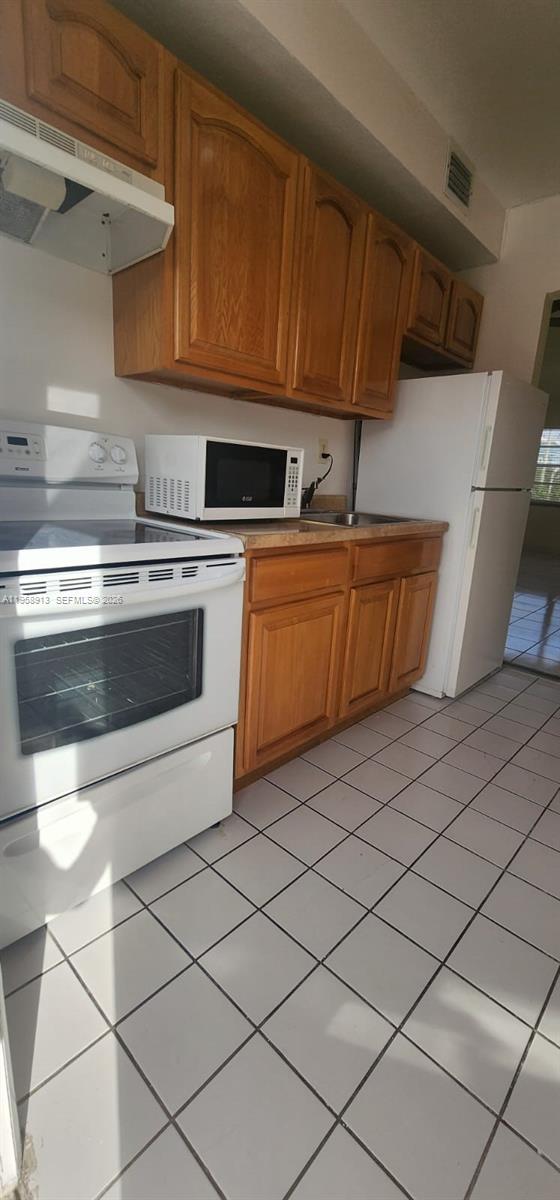 3670 Southwest 10th Street, Unit 10B Miami, FL 33135 - Photo 2 of 12 a kitchen with granite countertop a sink and a stove top oven