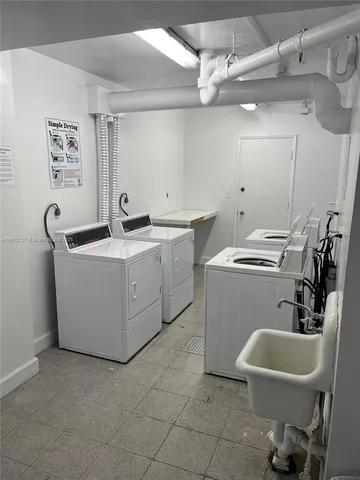 a utility room with sink dryer and washer