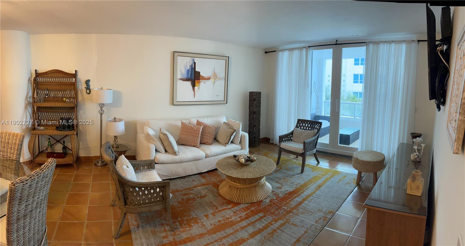 5005 Collins Avenue, Unit 923 Miami Beach, FL 33140 - Photo 5 of 17 a living room with furniture and a flat screen tv