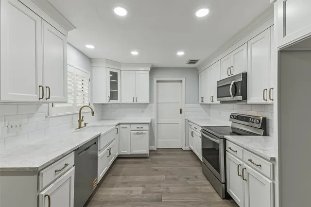 a kitchen with granite countertop sink stainless steel appliances and cabinets