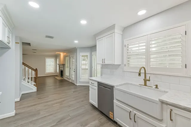 a kitchen with a sink and wooden floor