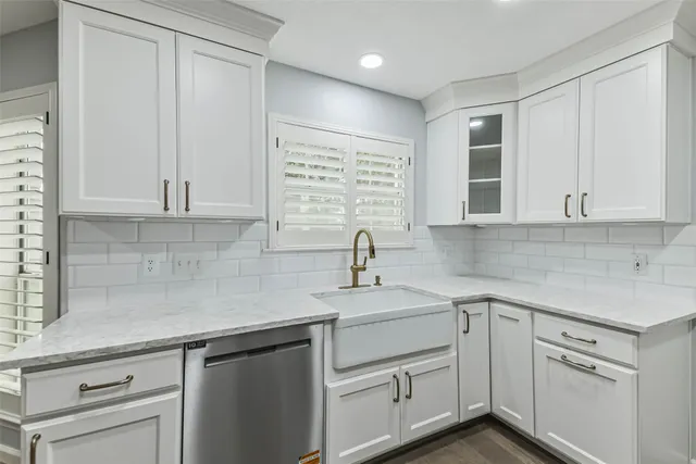 a view with white cabinets and sink