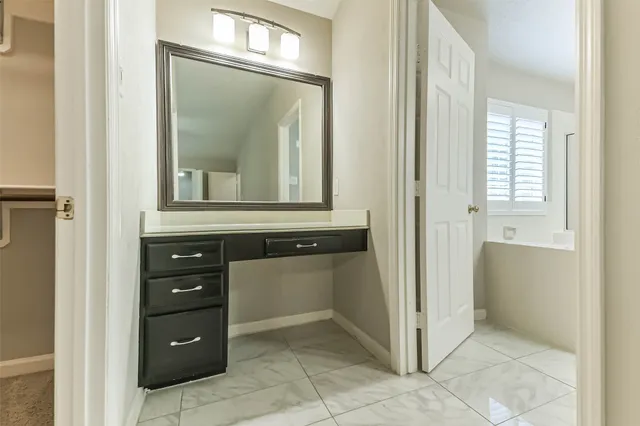 view of room with mirror and cabinets